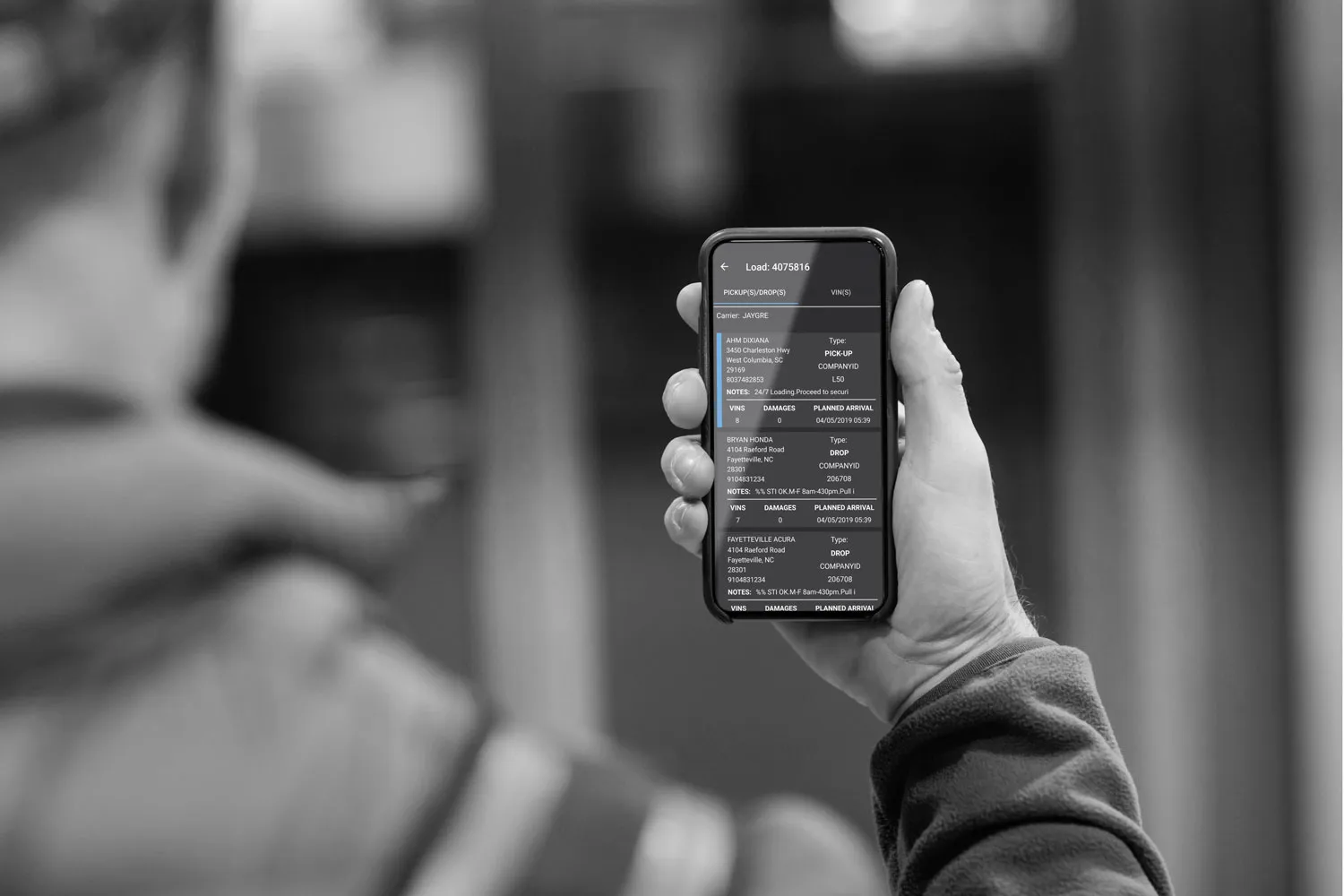 Driver holding a phone with the vehicle pickup app